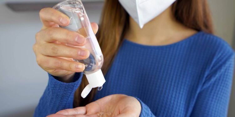 Pessoa passando álcool em gel nas mãos - Créditos: depositphotos.com / sergio_pulp