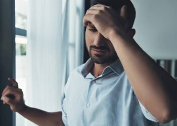 Homem com dores de cabeça provenientes da enxaqueca