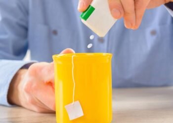 Homem usando adoçante direto na bebida em caneca