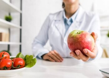 Médica segurando uma maçã em seu consultório
