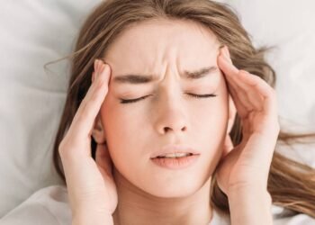 Mulher com os olhos fechados sofrendo com dores de cabeça