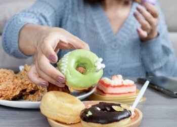Mulher comendo vários doces com alto teor de açúcar