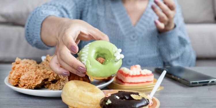 Mulher comendo vários doces com alto teor de açúcar