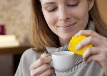 Mulher usando adoçante na bebida direto na xícara