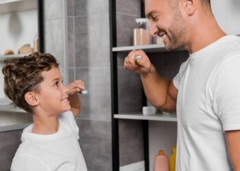 Pai e filho em rotina de escovar os dentes