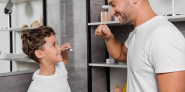 Pai e filho em rotina de escovar os dentes