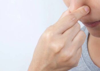 Pessoa tapando as próprias narinas para evitar inalação de ar