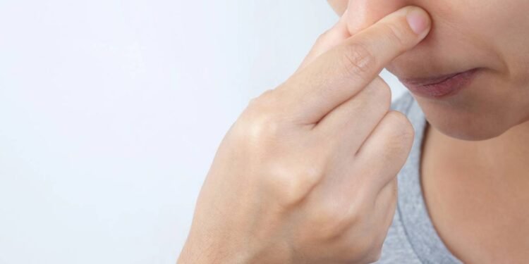 Pessoa tapando as próprias narinas para evitar inalação de ar