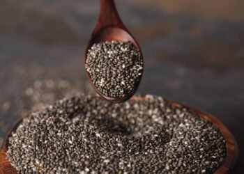 Sementes de chia sendo pegas de pote com ajuda de colher