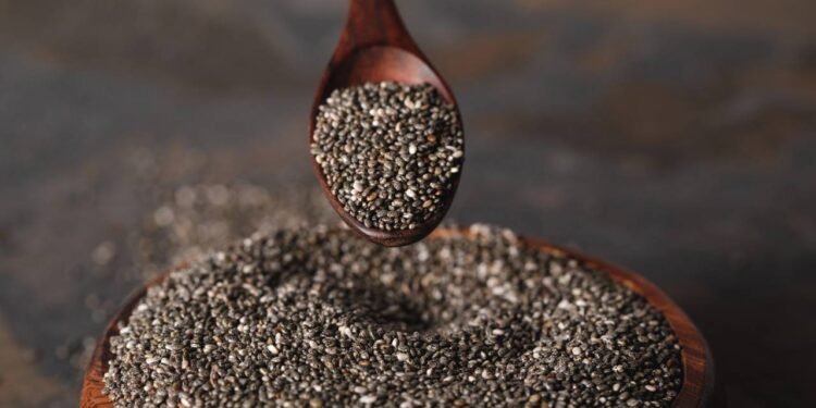 Sementes de chia sendo pegas de pote com ajuda de colher