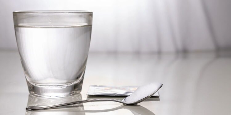 Copo com água e colher - Créditos: depositphotos.com / Thamkc