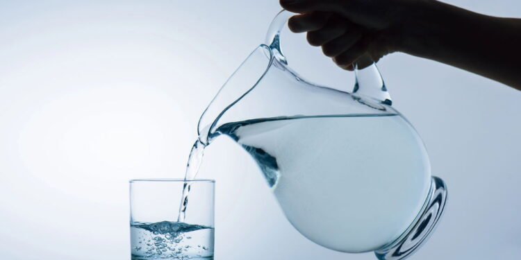 Pessoa servindo água pela jarra - Créditos: depositphotos.com / VadimVasenin