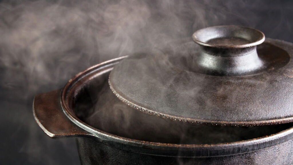 Por que colocar uma colher de pau sobre a panela evita que a água derrame?