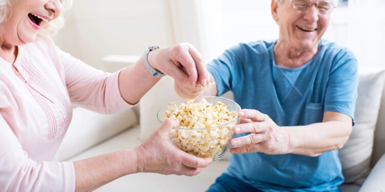 Idosos comendo pipoca - Créditos: depositphotos.com / ArturVerkhovetskiy