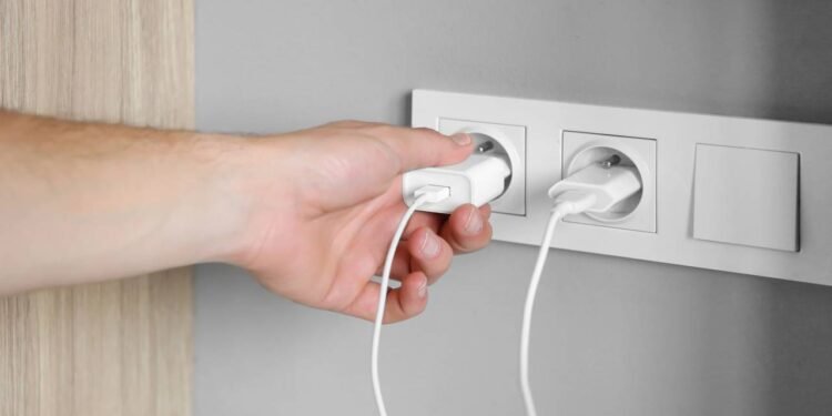 Carregador deixado na tomada consome energia mesmo sem uso e aumenta a conta de luz - Créditos: depositphotos.com / natali.maliarchuk