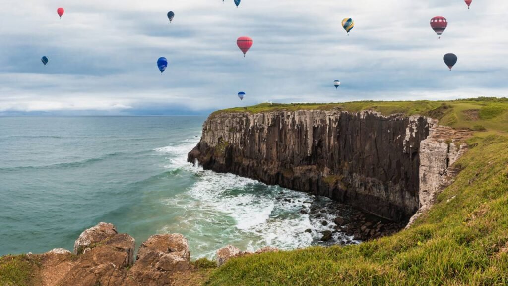 A cidade onde os balões coloridos voam sobre falésias e o mar encontra a serra com uma vista de tirar o fôlego