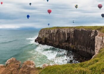 A cidade onde os balões coloridos voam sobre falésias e o mar encontra a serra com uma vista de tirar o fôlego