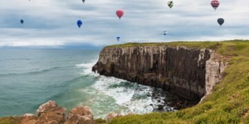 A cidade onde os balões coloridos voam sobre falésias e o mar encontra a serra com uma vista de tirar o fôlego