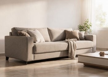 Quem cuida da casa no dia a dia sabe como o sofá é um dos móveis mais exigidos da sala, recebendo uso constante, contato com roupas, alimentos e até animais de estimação. Em 2026, o estofado de tom médio surge como uma escolha inteligente, equilibrando estética contemporânea e praticidade, ao reduzir o desgaste visual e facilitar a manutenção sem abrir mão de elegância. Por que o estofado de tom médio ganhou destaque nos lares modernos? A mudança no estilo de vida influenciou diretamente as escolhas para os ambientes de convivência, priorizando soluções que unam beleza e funcionalidade. Os tons médios aparecem como resposta a essa demanda, oferecendo mais tolerância às marcas do uso diário e criando uma base visual acolhedora. Antes de decidir pela troca do sofá, vale observar como essas tonalidades se comportam no cotidiano e por que elas se tornaram tão valorizadas nos projetos atuais. Disfarçam manchas leves e marcas de uso frequente, mantendo o visual uniforme por mais tempo. Reduzem a necessidade de limpezas profundas constantes, facilitando a rotina doméstica. Harmonizam facilmente com diferentes cores de almofadas, tapetes e cortinas. Como o desgaste visual influencia na escolha do sofá ideal? O desgaste visual é um fator decisivo para quem busca durabilidade estética, especialmente em salas com grande circulação. Sofás muito claros evidenciam rapidamente sujeiras e escurecimentos naturais do tecido, comprometendo a aparência geral do ambiente. Os tons médios equilibram esse efeito, pois suavizam contrastes e mantêm a superfície visualmente agradável mesmo após longos períodos de uso contínuo. Quais tecidos de tom médio oferecem mais resistência no uso diário? A escolha do tecido é tão importante quanto a cor, já que materiais inadequados podem comprometer a longevidade do estofado. Tecidos de tom médio costumam apresentar melhor desempenho quando aliados a tramas resistentes e tratamentos tecnológicos. Ao analisar as opções disponíveis, alguns materiais se destacam por unir conforto, resistência e facilidade de limpeza. Chenille e suede tecnológico, que oferecem toque macio e alta durabilidade. Linhos mistos, que mantêm aparência sofisticada e resistem bem ao uso contínuo. Tecidos com proteção impermeável, que evitam a absorção imediata de líquidos. De que forma os tons médios contribuem para uma decoração mais equilibrada? Além da praticidade, o estofado de tom médio funciona como um elemento visual neutro, capaz de valorizar outros itens do ambiente. Ele cria uma base sólida para composições mais ousadas ou minimalistas, conforme o estilo da casa. Essa versatilidade permite atualizar a decoração ao longo do tempo apenas trocando acessórios, mantendo o sofá como peça central elegante e funcional. Vale a pena investir nessa tendência pensando no longo prazo? Optar por um sofá de tom médio em 2026 é uma decisão alinhada ao uso consciente e à durabilidade do mobiliário. A redução do desgaste aparente prolonga a sensação de novo por mais tempo, evitando trocas frequentes. Para quem busca um lar bonito, prático e preparado para a rotina real, essa tendência se consolida como um investimento inteligente e coerente com as necessidades atuais.