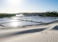 A 160 km da capital, o vilarejo sem carros e com travessia de 10 minutos, onde 2.104 moradores vivem entre dunas brancas e as maiores salinas do Brasil