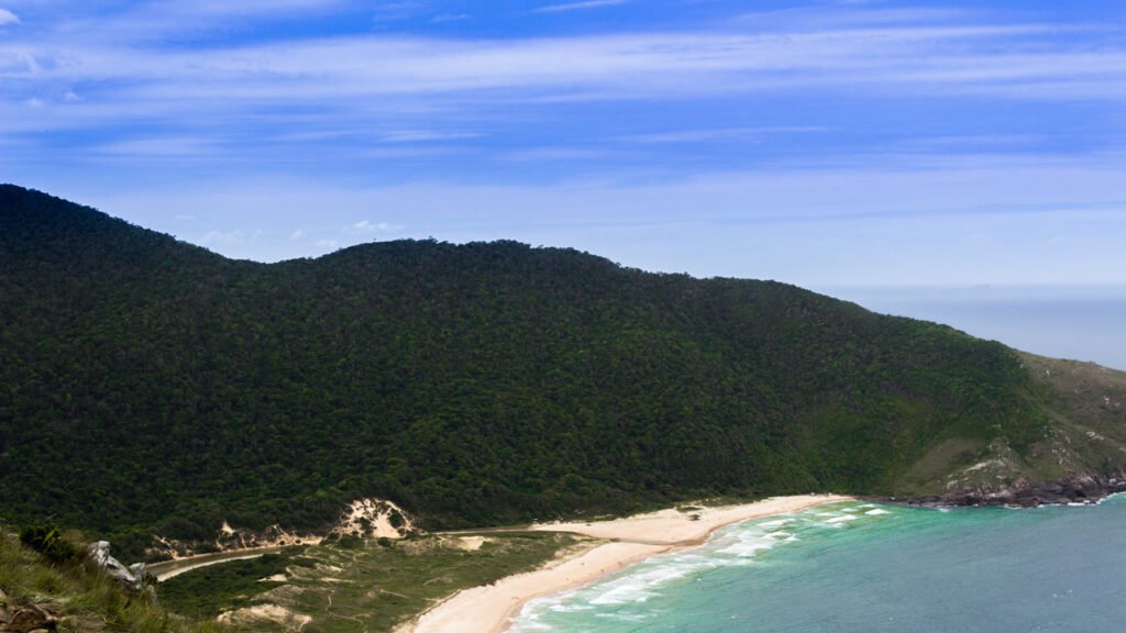 A praia selvagem da capital: acessível só por trilha ou barco, com lagoa, mar azul e zero prédio à vista no coração da capital