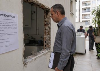 Dois vizinhos abriram uma porta pro pátio do prédio sem permissão e colocaram máquina de lavar e plantas: a Justiça INTERVEIO Transformar uma janela em porta para acessar o pátio do condomínio sem pedir licença? Não deu nada bem, amiga! Um caso em Sevilha virou alerta sobre o uso de áreas comuns em condomínios. Bora entender seus direitos e evitar confusão com a vizinhança? O que aconteceu no caso da porta aberta em área comum do condomínio? Dois proprietários de um edifício em Sevilha converteram uma janela em porta para ter acesso direto a um pátio comum, sem pedir autorização da comunidade de condôminos. Além disso, instalaram máquina de lavar e vasos de plantas no espaço coletivo, segundo decisão divulgada pelo Poder Judicial da Espanha. O Tribunal Provincial de Sevilha foi categórico: as obras eram ilegais. Por isso, determinou a remoção de todos os objetos e a restauração completa da área ao estado original. Esse caso virou referência sobre uso de áreas comuns em condomínios! O que nunca se deve fazer em áreas comuns do condomínio? Converter janelas em portas ou abrir novos acessos sem aprovação formal da comunidade. Instalar eletrodomésticos ou móveis pessoais em pátios, corredores ou halls coletivos. Ocupar espaços comuns com vasos, bicicletas ou objetos de uso exclusivo por tempo prolongado. Realizar qualquer obra que altere elementos estruturais sem projeto e autorização em assembleia. Basear-se no comportamento de outro vizinho para justificar infrações próprias. Não rola!