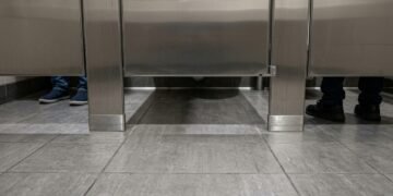 Por que os banheiros públicos deixam espaço entre a porta e o chão?