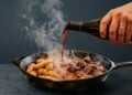 Batatas com carne são cozidas com um copo de vinho e caldo, não com água