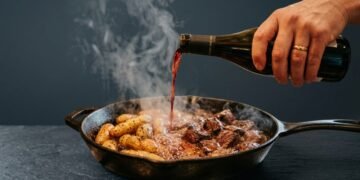 Batatas com carne são cozidas com um copo de vinho e caldo, não com água