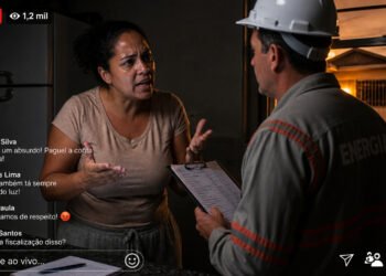 Moradora discute com um funcionário da companhia de energia dentro de uma casa sem iluminação, enquanto uma transmissão ao vivo exibe comentários de apoio e reclamações de outros usuários.