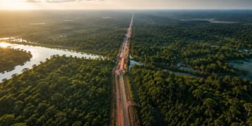 Vista aérea da BR-319 atravessando uma extensa área de floresta amazônica, com rios e trechos alagados ao redor da estrada.