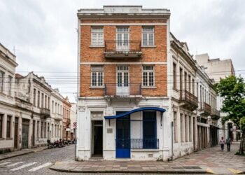 Tijolo aparente e metal azul transformam uma casa brasileira dos anos 1930 em um centro cultural