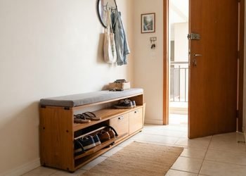 O mesmo móvel usado para sentar pode esconder os pares que normalmente ficam espalhados perto da porta