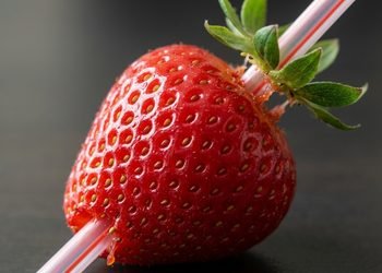 O canudo atravessa o centro da fruta e empurra o cabinho para fora pelo topo - Imagem ilustrativa