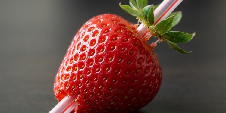 O canudo atravessa o centro da fruta e empurra o cabinho para fora pelo topo - Imagem ilustrativa